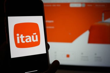 Roosendaal; Hollanda - 13 Şubat 2025: Itau logosunu gösteren bir cep telefonu; şirketin web sitesi arka planda.