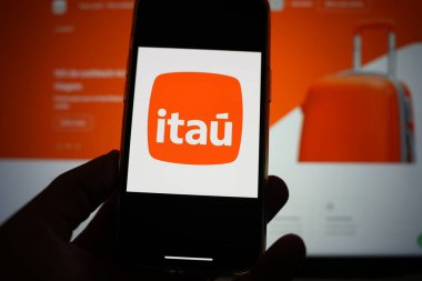 Roosendaal; Hollanda - 13 Şubat 2025: Itau logosunu gösteren bir cep telefonu; şirketin web sitesi arka planda.
