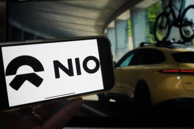 Roosendaal, Hollanda - 15 Şubat 2025: NIO logosunu gösteren bir cep telefonu, arka planda şirketin web sitesi.