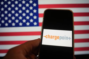 Roosendaal, The Netherlands - February 15, 2025: A mobile phone displaying the logo of ChargePoint, with the flag of the United States in the background clipart