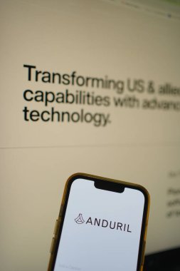 Roosendaal, Hollanda - 27 Temmuz 2025: Arka planda web sitesi bulunan bir savunma teknolojisi şirketi olan Anduril 'in logosunu gösteren cep telefonu.