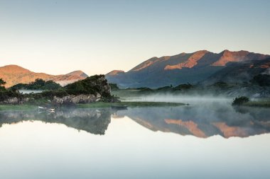 Killarney, Kerry, İrlanda 'daki Yukarı Göl' deki yansımalarla baş döndürücü bir sabah.