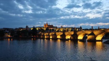 Sunset 'teki Aydınlanmış Charles Köprüsü ve Prag Şatosu' nun Yansıtıcı Suyla Zaman Videosu