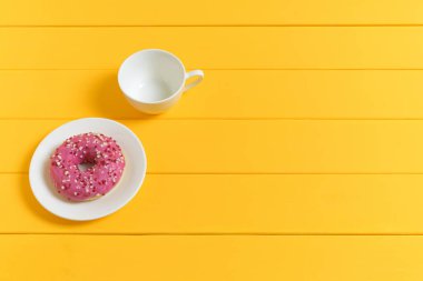 Boş Beyaz Kahve Fincanı ve Sarı Tahta Arkaplanda Pembe Donut