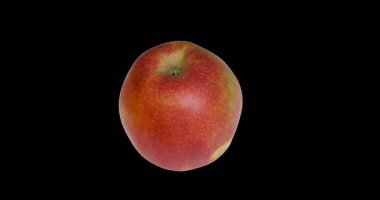 Yumuşak stüdyo ışıklarıyla ayna yüzeyinde dönen kırmızı elma. Hareket bulanıklığı ve temiz minimalist geçmişe sahip sanatsal gıda konsepti.