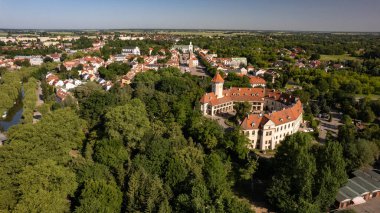 Kırmızı çatılı evleri, merkez meydanı ve yeşil ağaçlarla çevrili tarihi bir şatosu olan büyüleyici bir Polonya kasabası. Güneşli bir yaz gününde güzel bir Avrupa mimarisi.