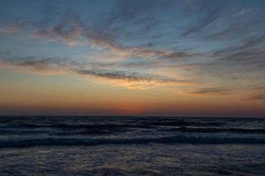 Arka planda güzel gökyüzü ile deniz üzerinde gün batımı