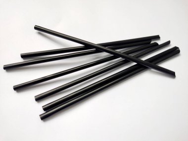 Beyaz arkaplanda siyah plastik pipetler