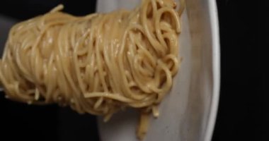 Beyaz arka planda geleneksel İtalyan yemeği hazırlamak için sahne arkası. Demir tavada krema soslu İtalyan makarnası pişirmek. Dikey video