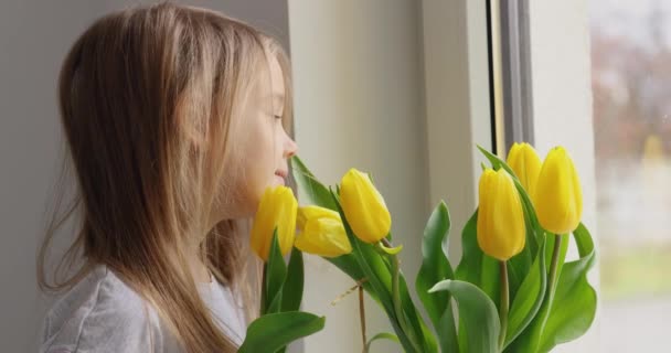 Küçük Kız Seviniyor Elinde Bir Buket Sarı Lale Ile Sarılıyor — Stok video