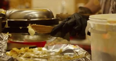 Akşamları Avrupa 'da bir Noel ve Yeni Yıl pazarında sokak tatlısı pişirmek. Waffle ızgarası üzerinde hazırlanıyor..