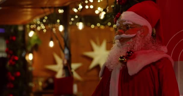 Brilho Noite Brinquedo Papai Noel Apresentado Contra Cenário Guirlanda Embaçado — Vídeo de Stock