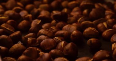 Arka plandaki videoda Avrupa 'daki bir Noel pazarında bol miktarda kavrulmuş kestane tasvir ediliyor.