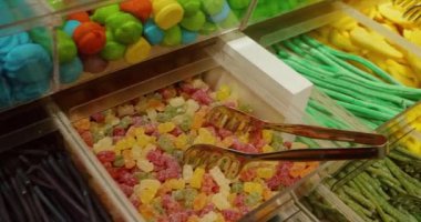 Videoda çeşitli diş etleri ve lolipoplar toplu olarak satılıyor..