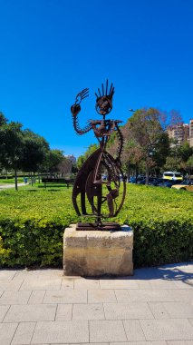 İspanya, Valencia 'da bir şehir parkında, hurda metalden yapılmış bir insan figürünün sanatsal bir temsilini içeren kırsal bir metal heykel..