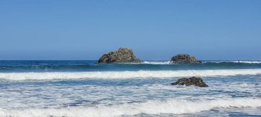 Okyanus dalgaları Tenerife, Kanarya Adaları, İspanya 'daki volkanik kaya kıyısına çarpıyor ve Atlantik kıyısının engebeli güzelliğini gözler önüne seriyor..