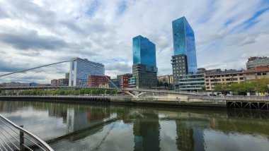 İspanya 'nın Bilbao kentindeki Moya Meydanı manzarası, tarihi mimari, merkezi bir çeşme, renkli bahçeler ve parlak mavi bir gökyüzü..