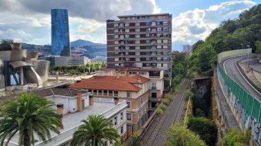 İspanya 'nın Bilbao şehrinde Guggenheim Müzesi, modern konut binaları ve yemyeşil alanlarla çevrili demiryolu hatları yer almaktadır..
