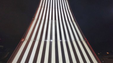 İspanya 'nın Bilbao kentindeki Zubizuri Köprüsü' nde gece gökyüzüne karşı aydınlatılmış siyah beyaz çizgili bir tasarımın sanatsal yakın çekimi..