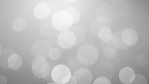 Değişen boyutlarda parlak daireleri olan gri tonlu bir bokeh arkaplanı