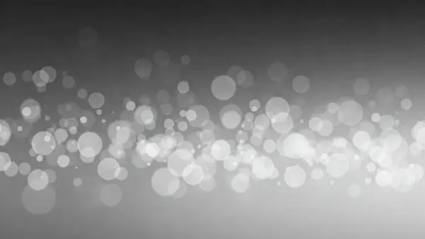 Değişen boyutlarda parlak daireleri olan gri tonlu bir bokeh arkaplanı
