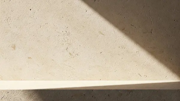 İnce, doğal dokuları olan bej taştan bir duvarın olduğu minimalist bir sahne.