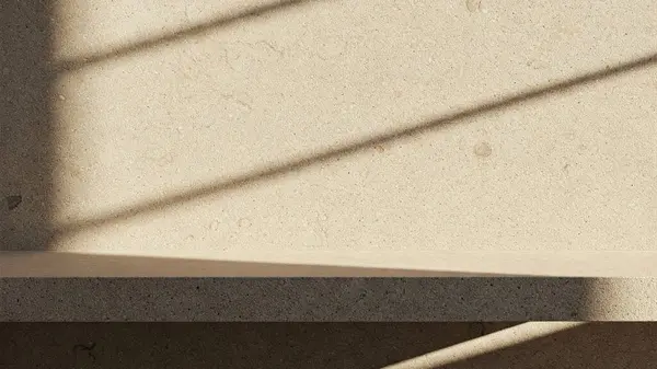 İnce, doğal dokuları olan bej taştan bir duvarın olduğu minimalist bir sahne.