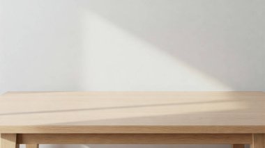 Temiz ve minimalist bir düzenek. Hafif ahşap bir masa ve düz beyaz bir duvar arka planı var.