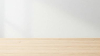 Temiz ve minimalist bir düzenek. Hafif ahşap bir masa ve düz beyaz bir duvar arka planı var.
