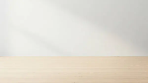 Temiz ve minimalist bir düzenek. Hafif ahşap bir masa ve düz beyaz bir duvar arka planı var.