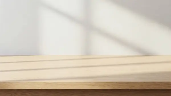 Temiz ve minimalist bir düzenek. Hafif ahşap bir masa ve düz beyaz bir duvar arka planı var.