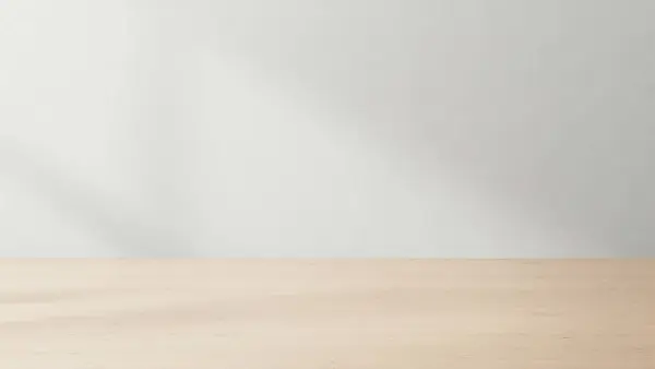 Temiz ve minimalist bir düzenek. Hafif ahşap bir masa ve düz beyaz bir duvar arka planı var.