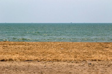 Sakin bir sahil, altın kumu ve berrak bir gökyüzünün altında sakin mavi bir deniz. Cox 's Bazar, Bengal Körfezi, Bangladeş