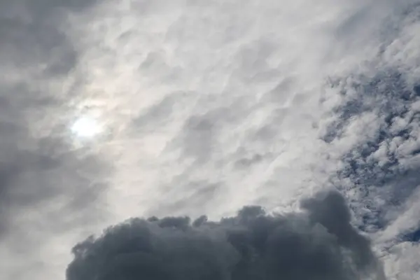 Yumuşak, ince bulutlarla dolu sakin bir gökyüzü parlak mavi bir zemin üzerinde, sakin ve huzurlu bir atmosfer yaratıyor..