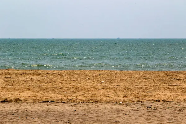 Sakin bir sahil, altın kumu ve berrak bir gökyüzünün altında sakin mavi bir deniz. Cox 's Bazar, Bengal Körfezi, Bangladeş