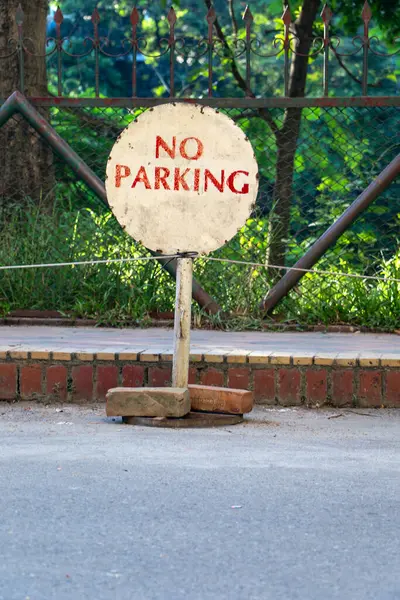 Çevresi yeşillik ve çitlerle çevrili kaldırımda yıpranmış bir 