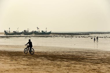 Sahilde bisiklet süren bir adam, Cox 's Bazar, Bengal Körfezi, Bangladeş