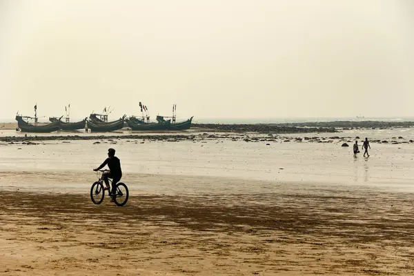 Sahilde bisiklet süren bir adam, Cox 's Bazar, Bengal Körfezi, Bangladeş
