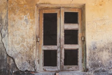 Sıkıntılı bir duvara yaslanmış eski bir pencerenin yer aldığı, çürümenin güzelliğini ve dokusunu bir nebze gizemle gösteren kırsal bir sahne..