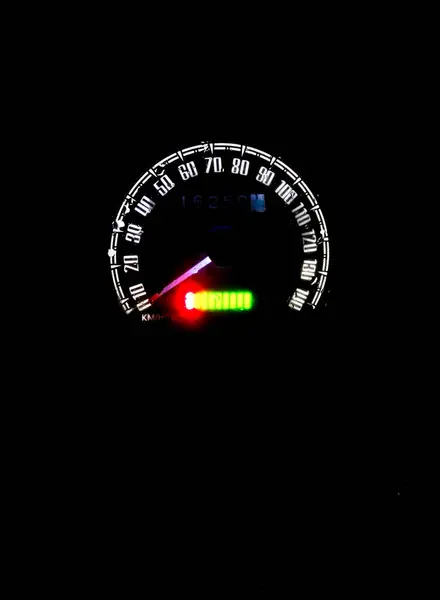 Motosiklet hız göstergesi, parlak ve parlak bir kontrast yaratan iğneler ve aydınlık ekranıyla karanlık bir ortamda ışığın tek noktasıdır. Gece sürüşünün ve teknolojik odak noktasının özünü yakalar.