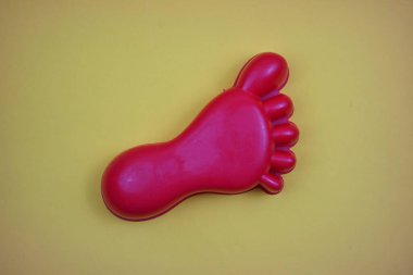 Kırmızı Ayaklı Plastik Oyuncak Sarı Arka plan 'da izole edildi. Metin için Boşluğu Kopyala. Üst Görünüm