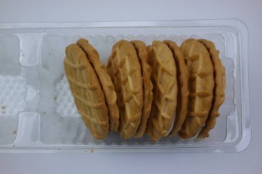 Şeffaf plastik kap içinde istiflenmiş kremalı sandviç kurabiyeleri