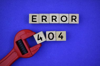 Error 404 written in wooden cubes on a blue background with a red wrench