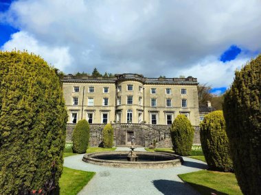 Rydal Hall, Ambleside, Cumbria, İngiltere 'de tarihi bir Gürcistan köşkü, taştan bir çeşmesi, çitleri ve resmi bahçeleri var. İngiliz kır evi, tarihi İngiliz malikanesi, bahçe mimarisi veya Lake District konağı fotoğrafçılığı gibi aramalar için ideal..