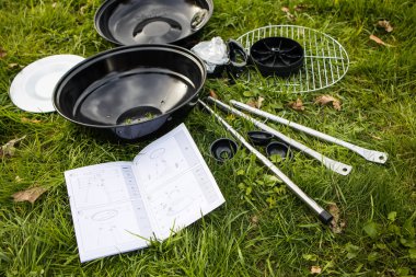 Parktaki yeşil çimlerin üzerinde parçalanmış yeni bir ızgara var.