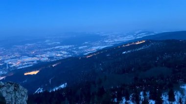 Liberec şehrinin akşam manzarası ve gözlem güvertesinden gün batımında parlak gökyüzü olan karla kaplı dağlar. Yüksek kalite 4k görüntü