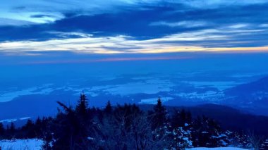 Geniş, karlı bir manzaranın nefes kesici bir görüntüsünü deneyimleyin. Canlı bir alacakaranlık altında aydınlanan.