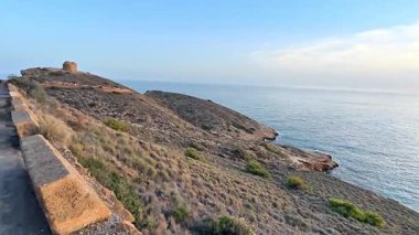 Nefes kesici kıyı manzarası gün batımında sakin bir gökyüzünün altında zarifçe sergileniyor.