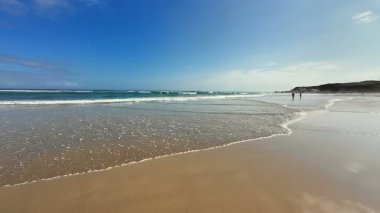 Sersemletici derecede güzel bir kumsal. Yumuşak dalgalar açık mavi gökyüzünün altında yuvarlanıyor. Rahatlamak ve gevşemek için ideal.