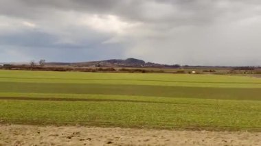 Bulutlu gökyüzünün altındaki yeşil alanların sakin görüntüsü güzelliği ve sükuneti takdir etmek için mükemmel.